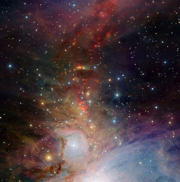 This infrared image of the Orion nebula shows the new (red) stars forming along twisting current filaments in a dusty plasma.